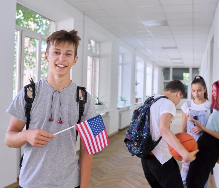 male-student-teenager-with-usa-flag-inside-college-group-of-students-background.jpg